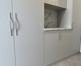 Matinė apdaila kuria švarų ir modernų vaizdą, o lankstytos rankenos pabrėžia baldų eleganciją. Stalviršio marmuro raštai puikiai dera su sienų plytelėmis, suteikdami interjerui išskirtinumą