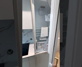 Moderni virtuvė su šviesiais matiniais fasadais. Sienelė ir stalviršis – iš kompaktiško HPL (aukšto slėgio laminato), kuris ne tik atrodo estetiškai, bet ir pasižymi atsparumu drėgmei bei karščiui