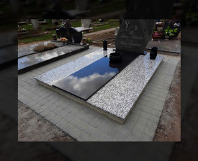 Pilnas kapavietės įrengimas: pamatų betonavimas, dengimas granito plokštėmis, trinkelių klojimas, aksesuarų (vazų) montavimas. Išlaikytas restauruojant senasis paminklas