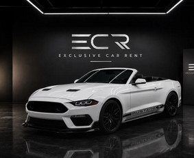 A 2021 Ford Mustang convertible in white with a turbocharged 2.3-litre engine (233 kW, about 315 hp) and rear-wheel drive. The roof drops at the press of a button, and it is the most affordable conve...