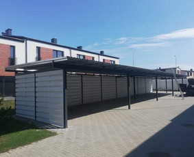 Automobilių stoginė. Metalinis karkasas, baltai dažytų lentų atitvaros, metalinė stogo danga. Projektuojame, gaminame ir montuojame.