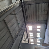 Patalpos padalinimas užbaigiant esamą pertvarą ir angos pakeliamiems vartams paruošimas.